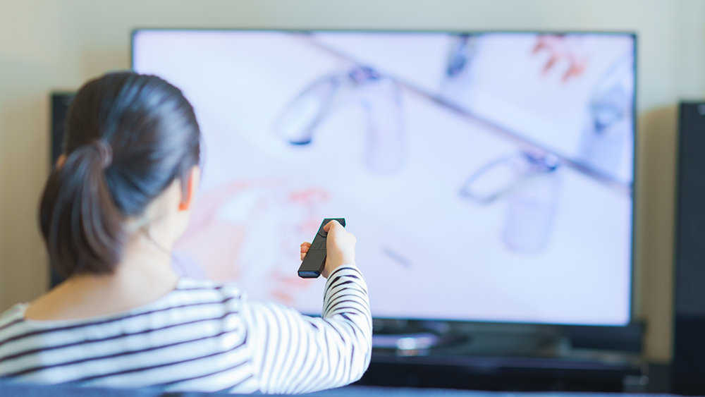 リモコンでテレビを設定しているシーン